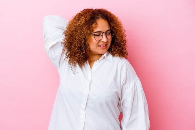 Young latin curvy woman isolated on pink wall suffering neck pain due to sedentary lifestyle.