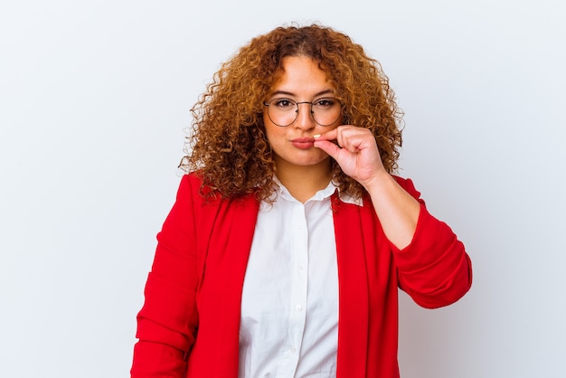 Young latin curvy woman isolated on white background with fingers on lips keeping a secret.