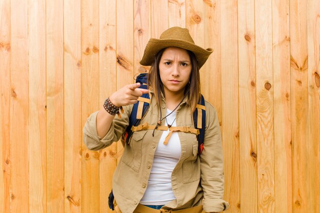 나무 벽 배경 젊은 라틴 탐험가 여자