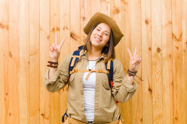 Young latin explorer woman against wooden wall background