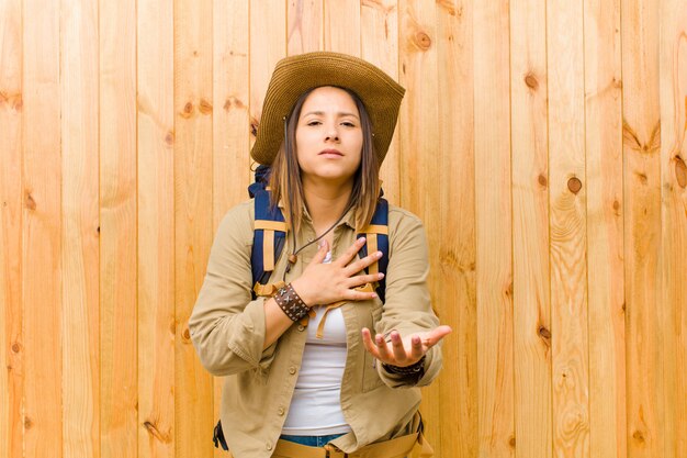 Young latin explorer woman against wooden  