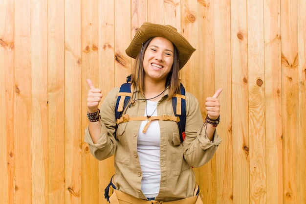 Young latin explorer woman on wooden wall