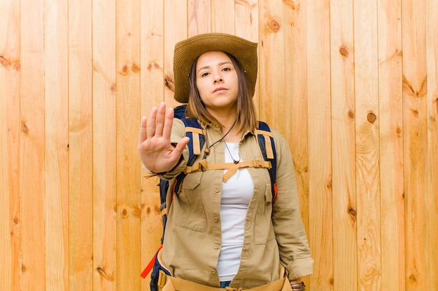 Young latin explorer woman on wooden wall