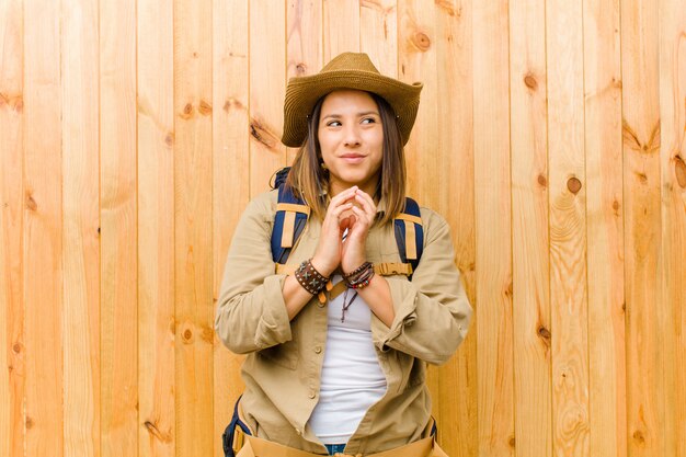 Young latin explorer woman on wooden wall