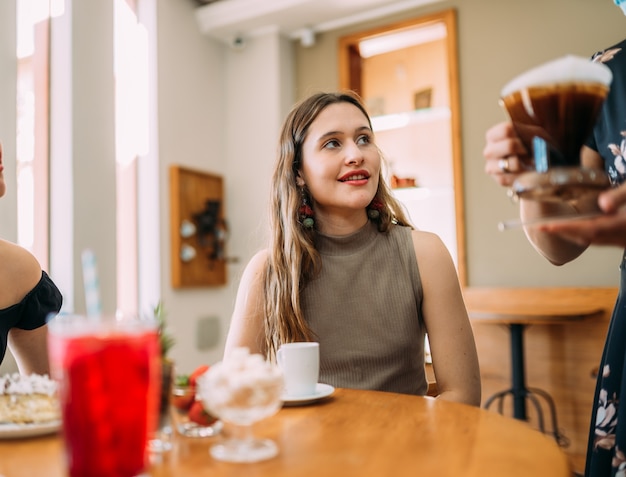 Young Latin girls sitting in cafe drinking coffee