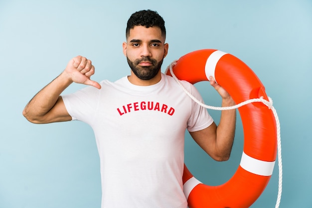 Young latin lifeguard man isolated showing a dislike gesture, thumbs down. Disagreement concept.