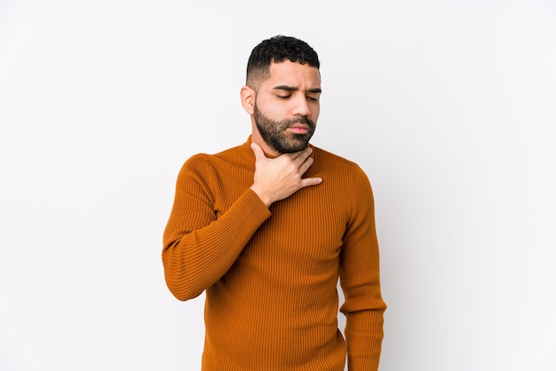 Young latin man against a white background isolated suffers pain in throat due a virus or infection.