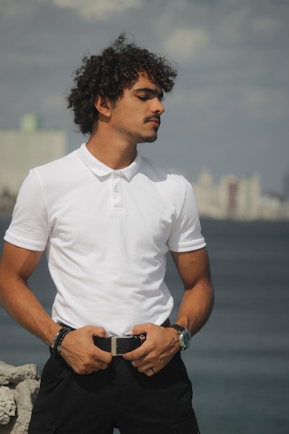 A young latin man at the coast wearing white tshirts