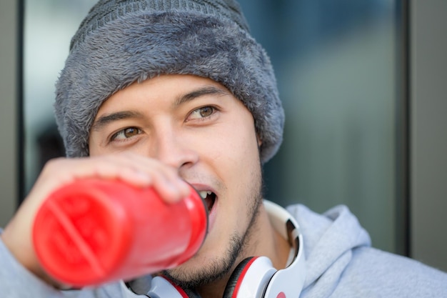 Foto giovane uomo latino che beve acqua corridore copyspace copia spazio inverno in esecuzione jogging sport allenamento fitness