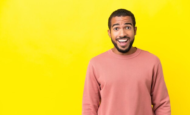 Young latin man isolated on yellow background with surprise facial expression