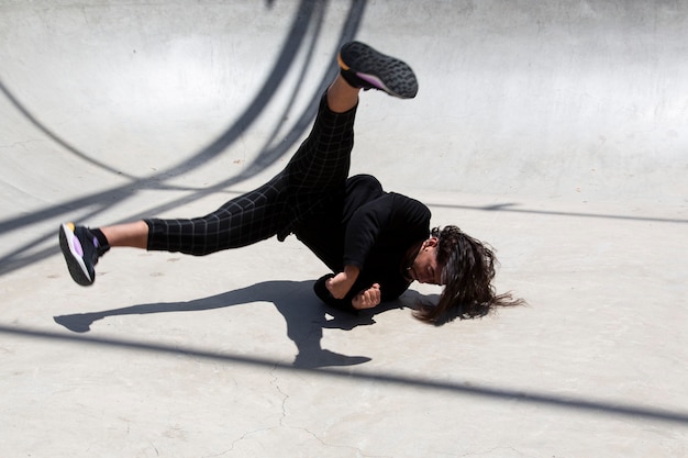 Young latin man performing street dance inside skating pit.