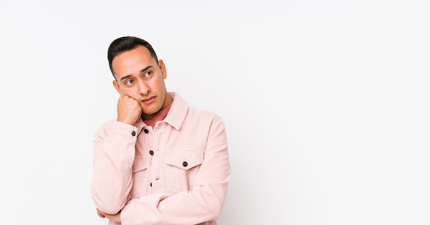 Young latin man posing isolated who feels sad and pensive, looking at copy space.