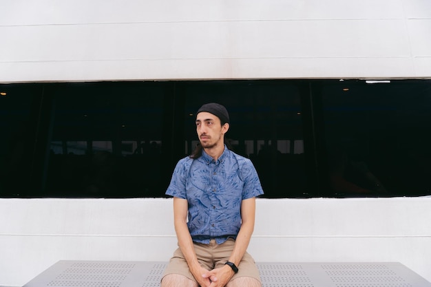 Young Latin man sitting on the side of a ferry quietly observing the landscape