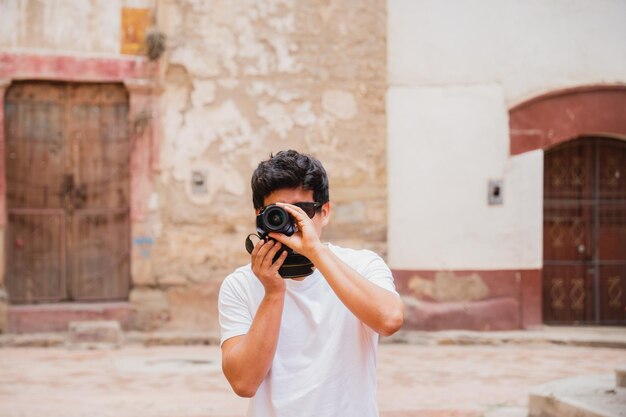 ラテン系若い男性旅行者写真家古代の都市で写真を撮っています