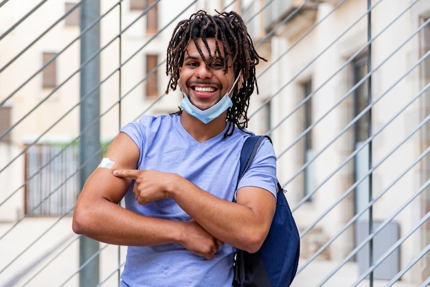 Photo young latin man vaccinated showing his arm