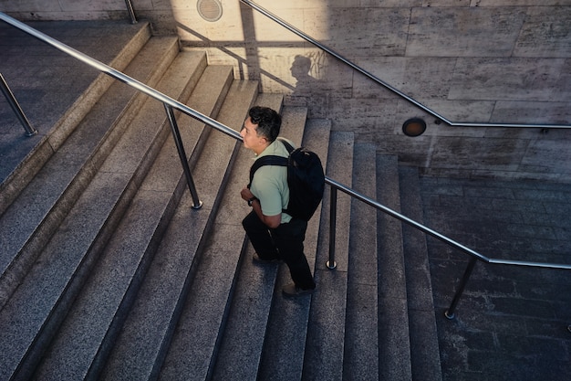 계단을 걷는 젊은 라틴 남자. 지하철 출구. 도시 생활 개념