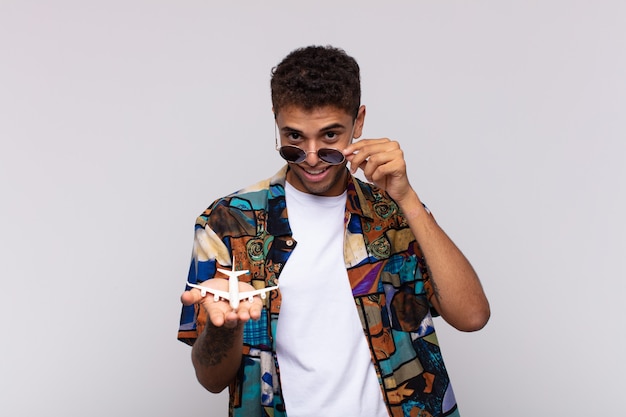 Young latin man with a plane. travel concept