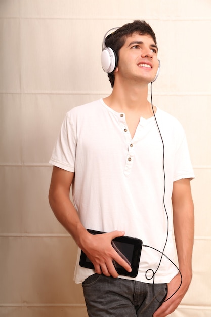 Un giovane uomo latino con un tablet pc e le cuffie