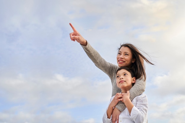 Young latin mother with child pointing to some point.