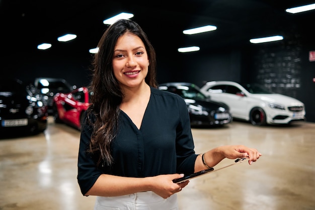 고급 자동차를 판매하는 젊은 라틴 판매원