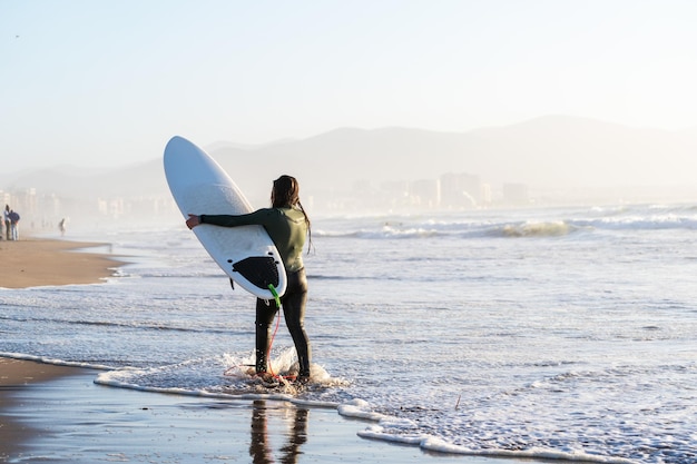 Photo young latin surfer with the board