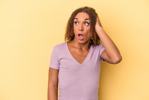 Young latin transsexual woman isolated on yellow background being shocked, she has remembered important meeting.