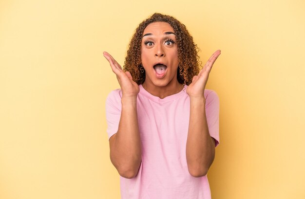 Young latin transsexual woman isolated on yellow background surprised and shocked.