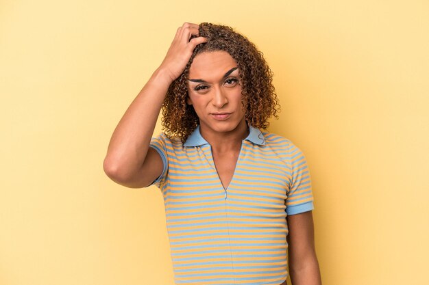 Young latin transsexual woman isolated on yellow background tired and very sleepy keeping hand on head.