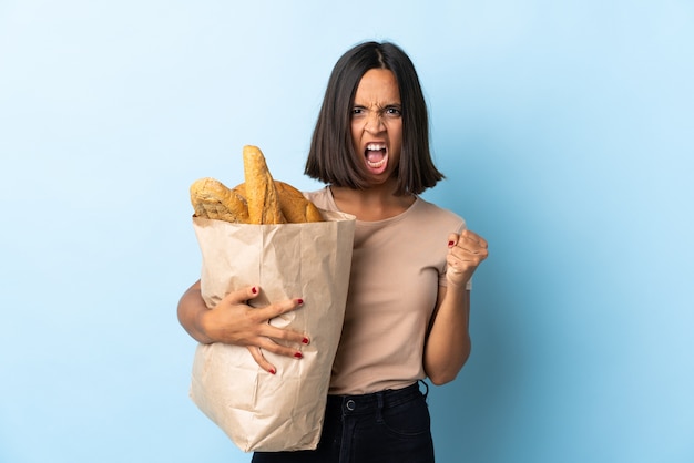 Young latin woman buying some breads isolated