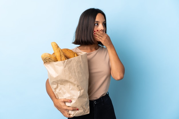 Молодая латинская женщина покупает хлеб изолированные