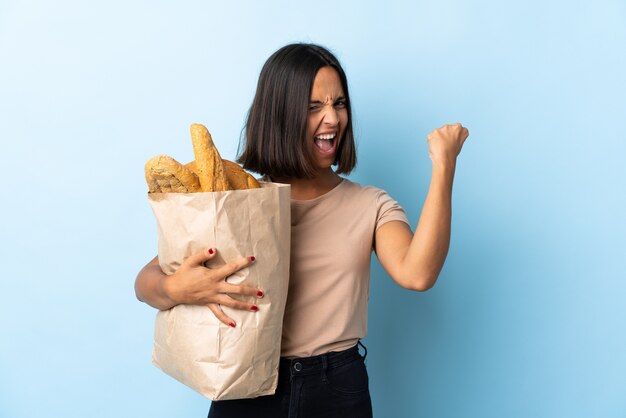 Молодая латинская женщина покупает хлеб