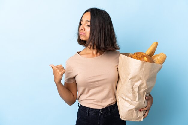 Young latin woman buying some breads