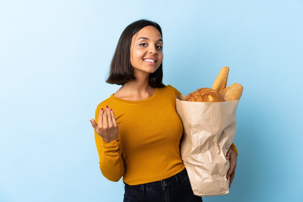 Young latin woman buying some breads