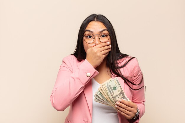 Young latin woman covering mouth with hands with a shocked, surprised expression, keeping a secret or saying oops