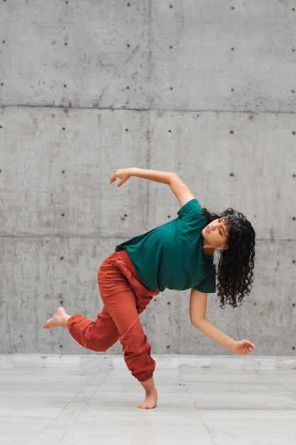 A young Latin woman dancing in an empty stage