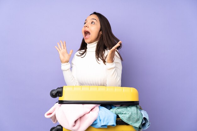 Young latin woman doing a suitcase isolated