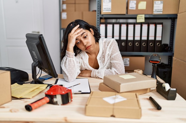 Young latin woman ecommerce business worker stressed working at office