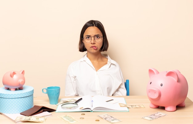 Young latin woman feeling clueless, confused and uncertain about which option to pick, trying to solve the problem