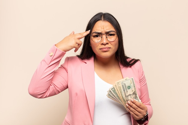 Photo young latin woman feeling confused and puzzled, showing you are insane, crazy or out of your mind