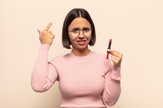 Young latin woman feeling confused and puzzled, showing you are insane