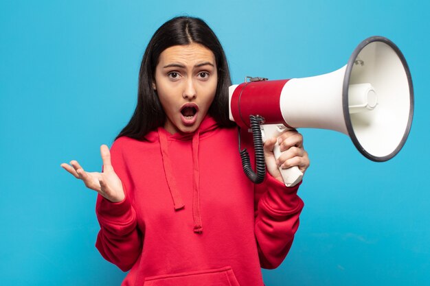 Photo young latin woman feeling extremely shocked and surprised, anxious and panicking, with a stressed and horrified look