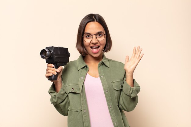 Photo young latin woman feeling happy, excited, surprised or shocked, smiling and astonished at something unbelievable