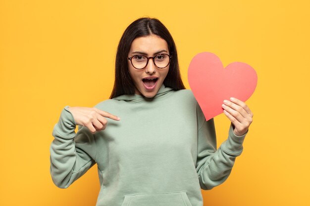 young latin woman feeling happy, surprised and proud, pointing to self with an excited, amazed look