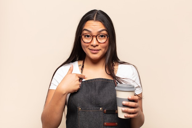 Young latin woman feeling happy, surprised and proud, pointing to self with an excited, amazed look