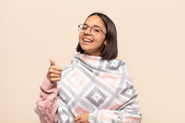 Young latin woman feeling proud, carefree, confident and happy, smiling positively with thumbs up