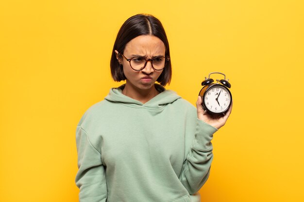 Young latin woman feeling sad, upset or angry and looking to the side with a negative attitude, frowning in disagreement