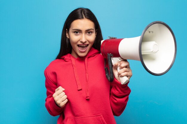 Giovane donna latina che si sente scioccata, eccitata e felice, ride e celebra il successo, dicendo wow!