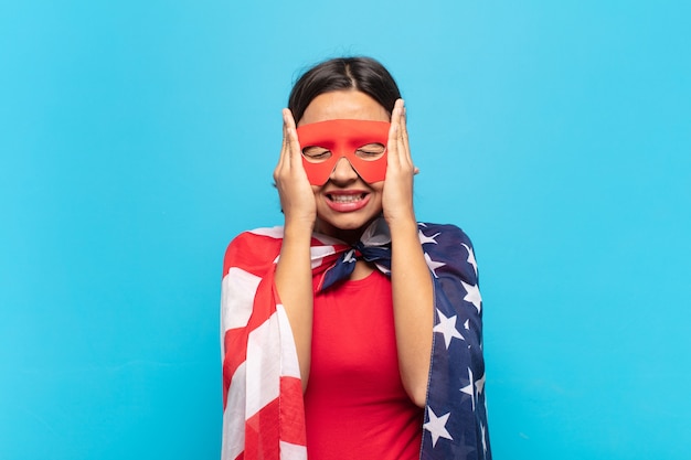 Young latin woman feeling stressed and anxious, depressed and frustrated with a headache, raising both hands to head