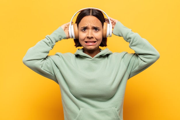 Young latin woman feeling stressed, worried, anxious or scared, with hands on head, panicking at mistake