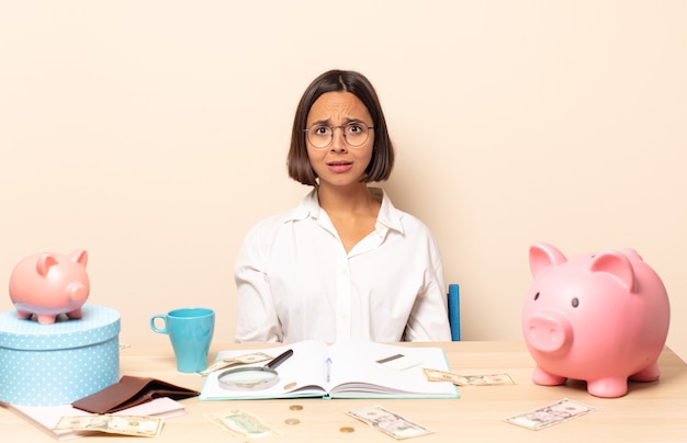 Young latin woman feeling terrified and shocked, with mouth wide open in surprise